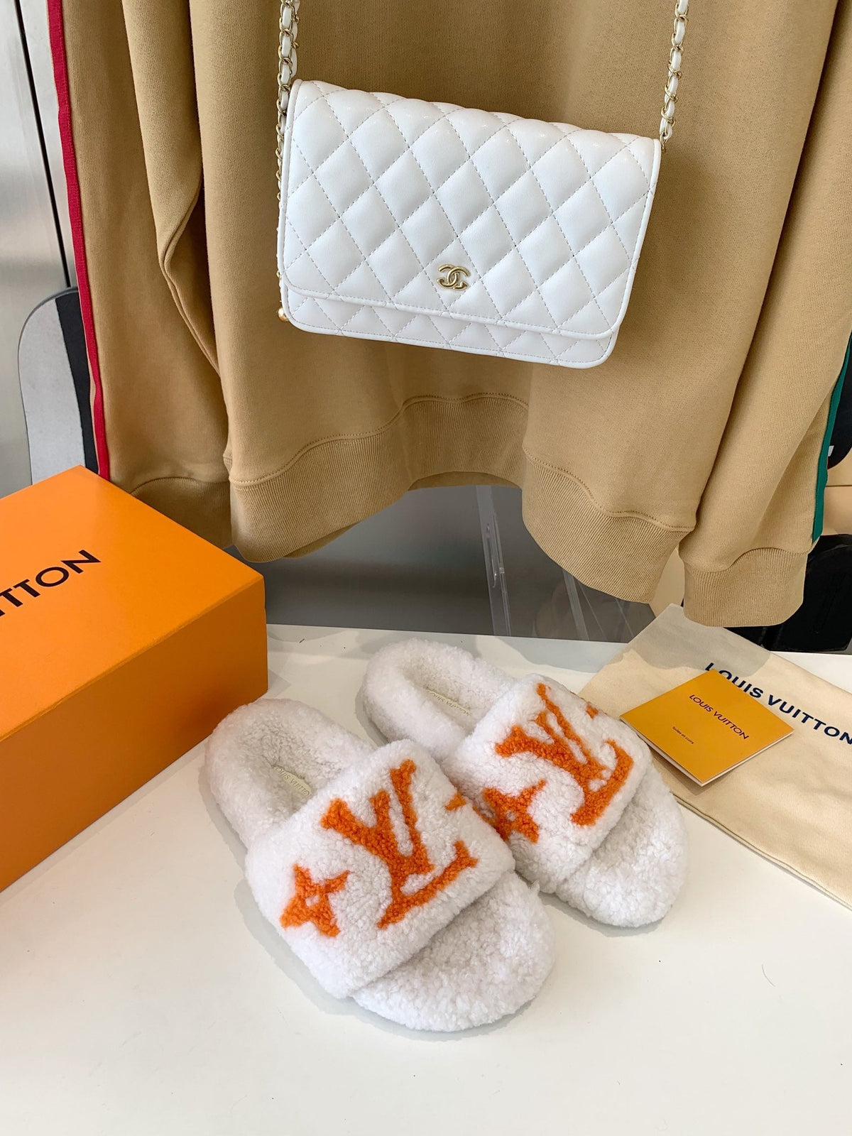 LV WOMEN'S PASEO FLAT SLIPPER IN WHITE FLEECE WITH ORANGE LOGO