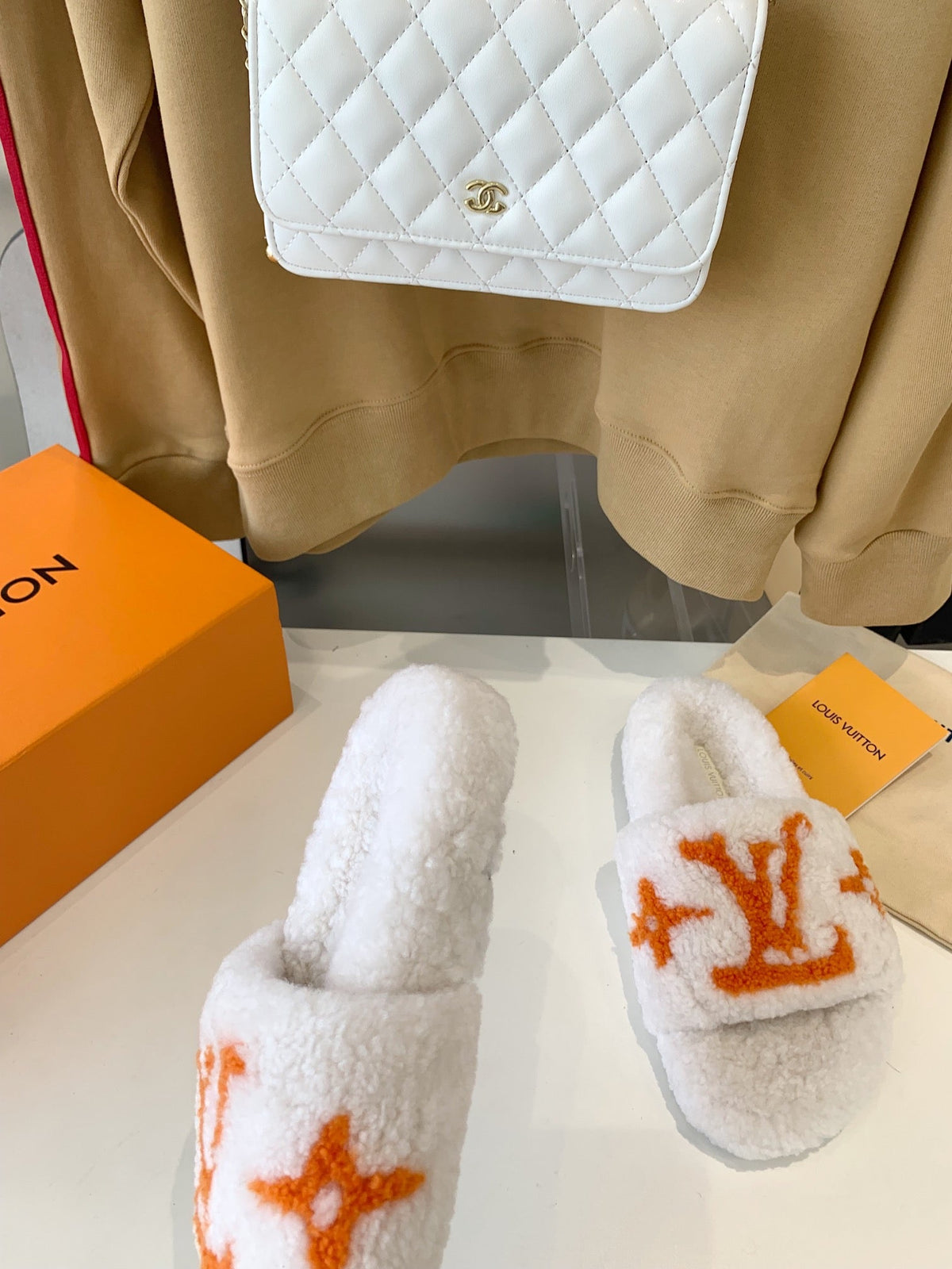 LV WOMEN'S PASEO FLAT SLIPPER IN WHITE FLEECE WITH ORANGE LOGO