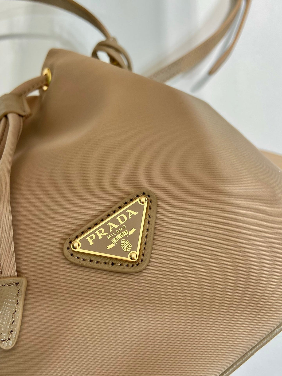 BUCKET BAG 19 IN BEIGE RE-NYLON AND SAFFIANO LEATHER HANDLE