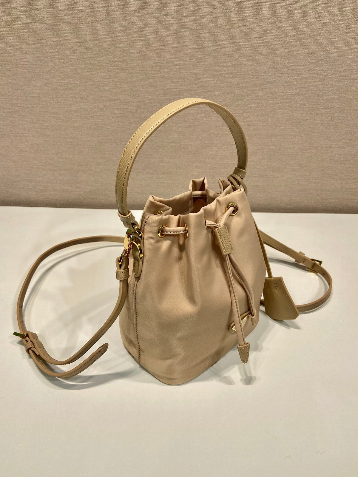 BUCKET BAG 19 IN BEIGE RE-NYLON AND SAFFIANO LEATHER HANDLE