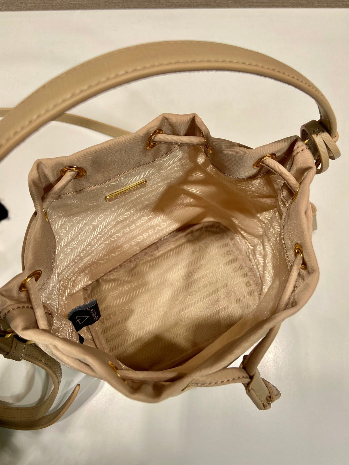 BUCKET BAG 19 IN BEIGE RE-NYLON AND SAFFIANO LEATHER HANDLE