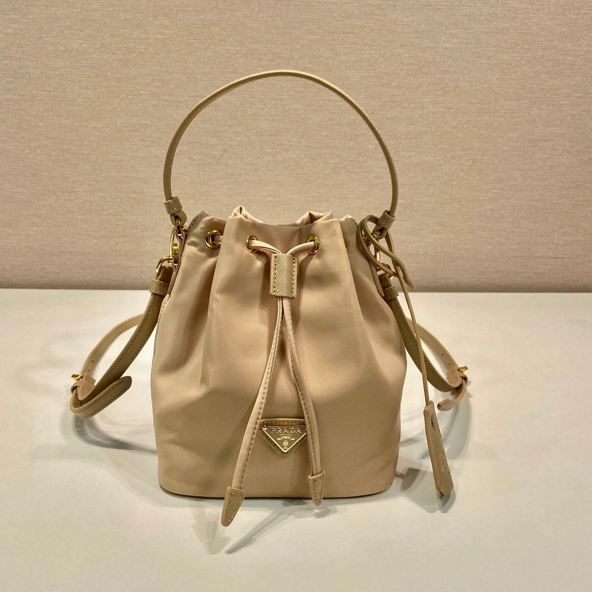 BUCKET BAG 19 IN BEIGE RE-NYLON AND SAFFIANO LEATHER HANDLE