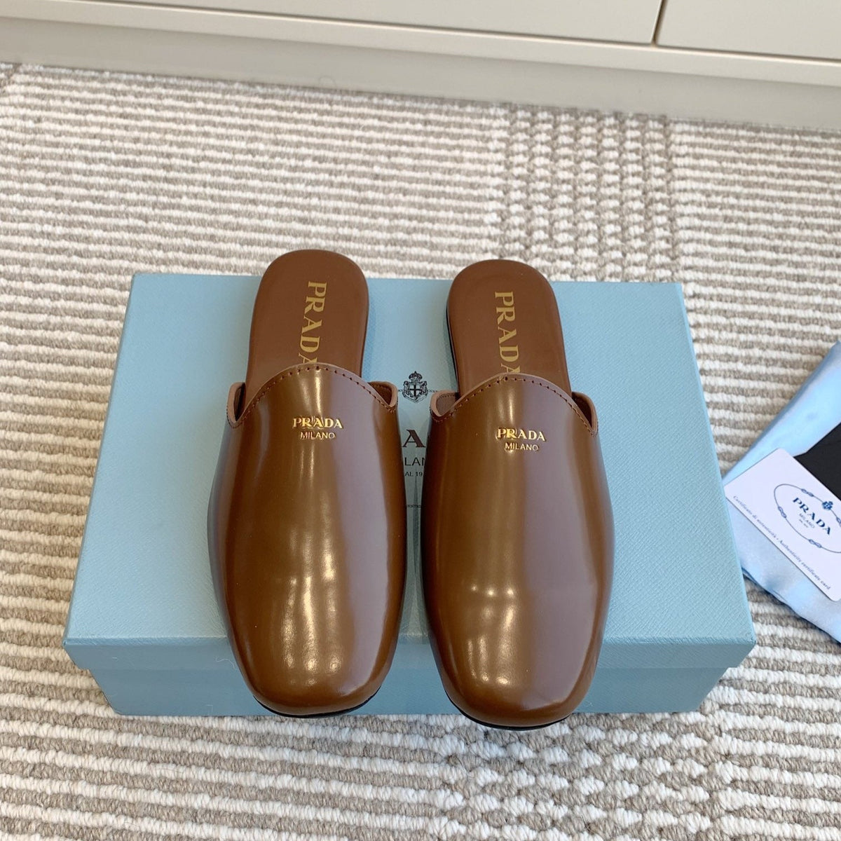 MULES IN BROWN GLOSSY SHEEPSKIN GOLD LETTERING LOGO