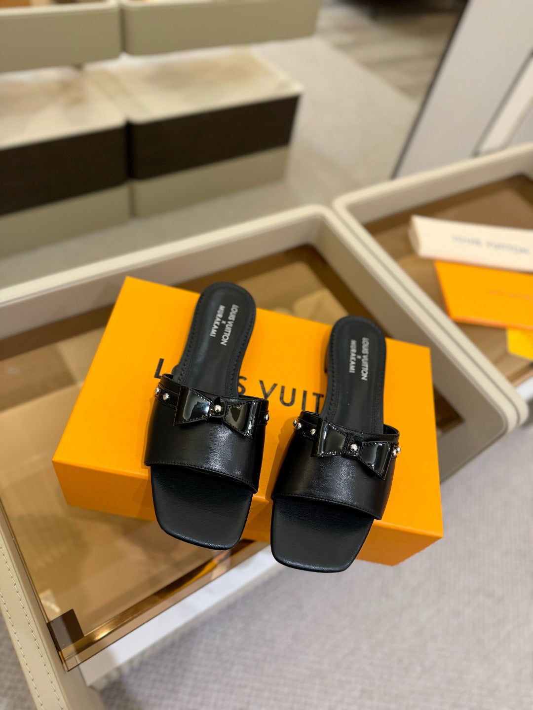 LV X TM 6AM FLAT MULE IN BLACK CALFSKIN