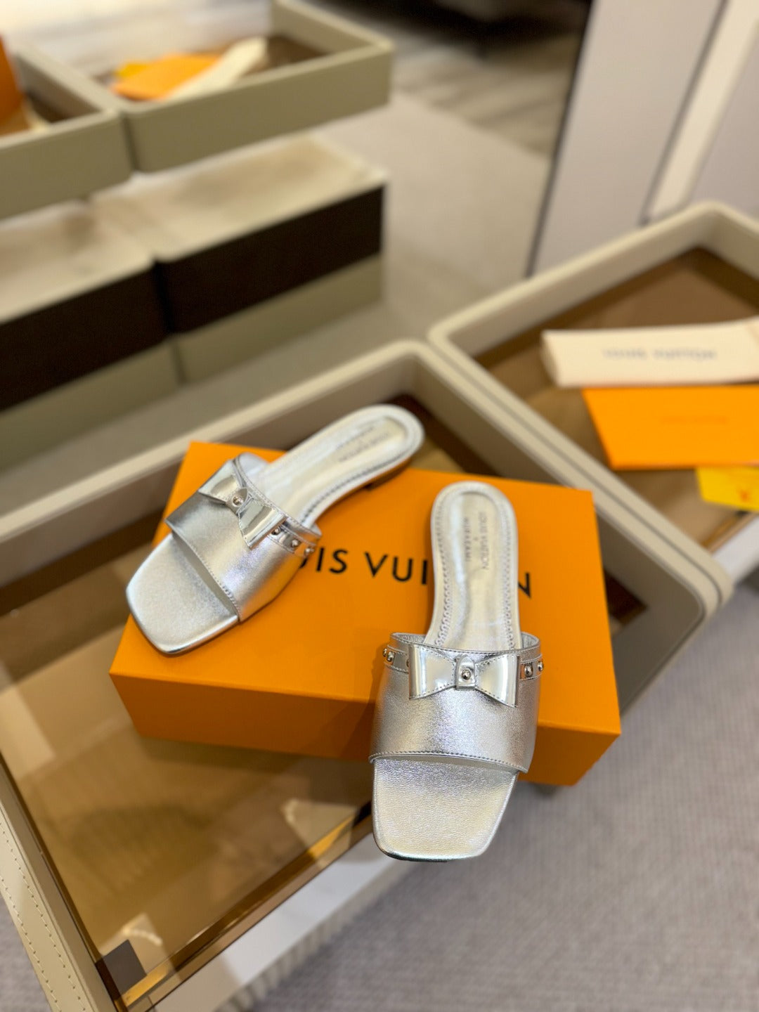 LV X TM 6AM FLAT MULE IN SILVER CALFSKIN